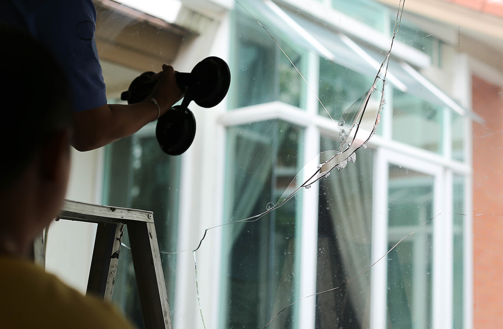 Repair man working on broken glass in the house